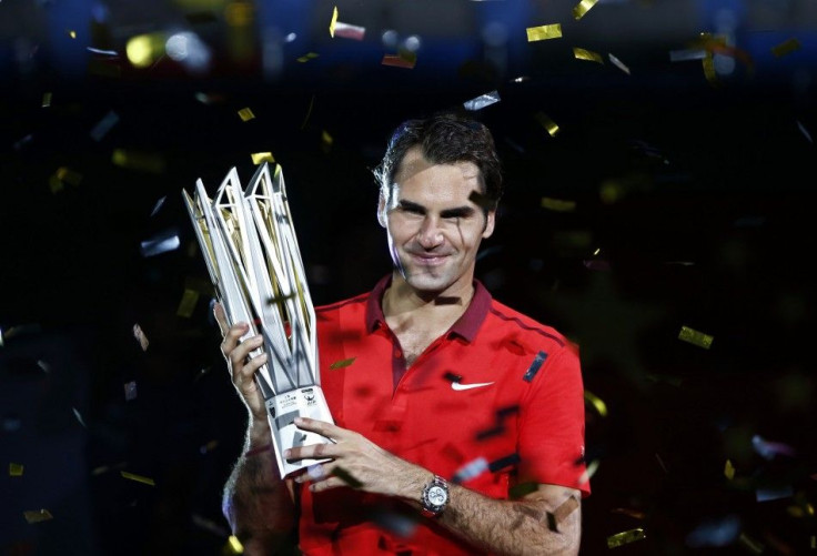 Roger Federer of Switzerland poses with the trophy after winning the men's singles final match against Gilles Simon of France at the Shanghai Masters tennis tournament in Shanghai October 12, 2014. Federer claimed one of the few titles to have previo