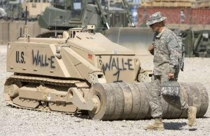 A U.S. Army's soldier walks past a de-mining robot