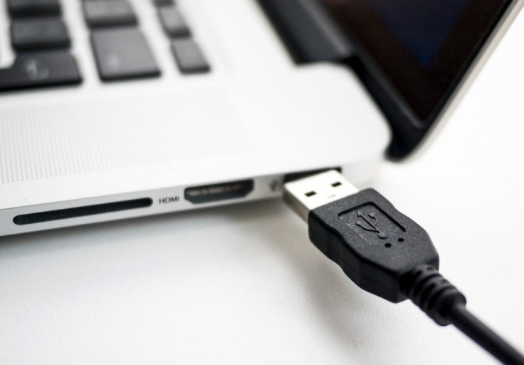 A USB Device Being Plugged Into A Laptop Computer