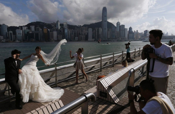 A couple takes wedding photos on the waterfront with a backdrop of Hong Kong&#039;s business Central district June 18, 2014. Hong Kong holds a controversial &quot;referendum&quot; on democracy on Friday, a prelude to an escalating campaign of dissent that