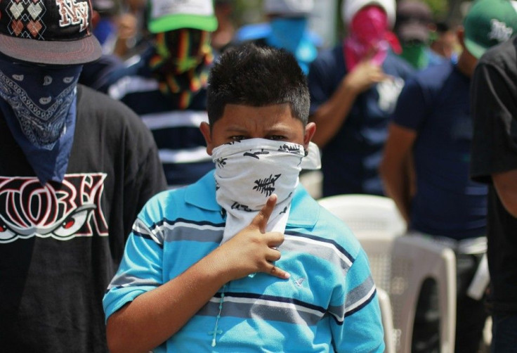 A young member of the Mara MS 13 street gang gestures while singing the national anthem during an event sponsored by the country's Catholic church at a park in San Vicente April 5, 2013. Members of the country's two most powerful gangs MS-13 and 18th Stre