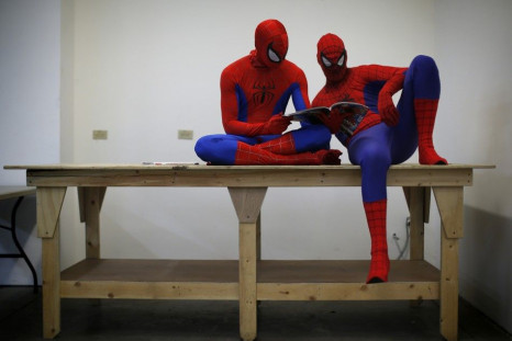 Peter Norbot and Kris Hamilton (L), dressed up as fictional comic book superhero Spider-Man, look through a magazine as they wait for their turn to audition to be a part of a promotional campaign for the upcoming release of the new movie &quot;The Amazing