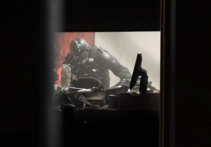 A police officer is seen after entering a room to rescue a girl held hostage by a man at a legal office in Parramatta