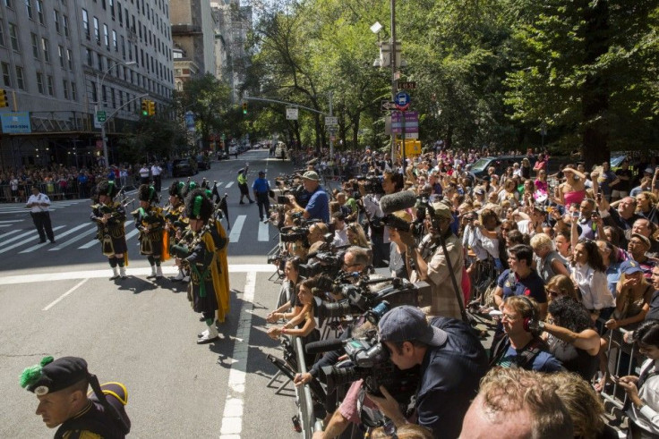 Member of a bagpipe ensemble perform as members of the media and fans watch mourners depart the funeral of comedian Joan Rivers at Temple Emanu-El in New York September 7, 2014.