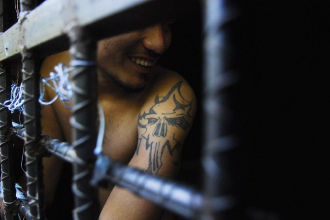 A man arrested this week for being a member of the MS-13 Mara Salvatrucha street gang among other crimes, smiles from inside a jail cell at a police station in San Salvador October 12, 2012. The U.S. on Thursday imposed financial penalties on violent Lati