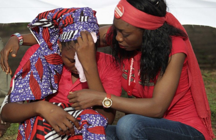 Isaac Rebecca, one of the girls that escaped from the Boko Haram camp is comforted during a protest march, in continuation of the Global Week of Action to commemorate six months since the abduction of the 219 Chibok school girls, organized by the Abuja &q