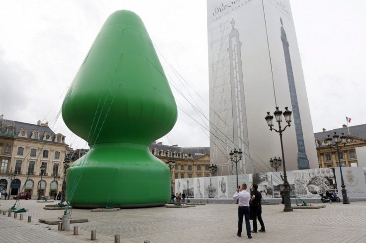 People look at U.S. Artist Paul McCarthy's 'Tree' creation which is displayed on the Place Vendome in Paris October 16, 2014. 'Tree' is an 25 meter-high inflatable sculpture as part of the International Contemporary Art Fair (FIAC) which runs from October
