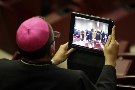 A bishop takes a picture with a tablet during a synod of bishops in Paul VI&#039;s hall at the Vatican October 6, 2014. Pope Francis on Monday opened the Roman Catholic assembly that will discuss marriage, gay couples, birth control and other moral issues