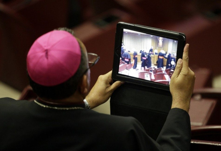 A bishop takes a picture with a tablet during a synod of bishops in Paul VI&#039;s hall at the Vatican October 6, 2014. Pope Francis on Monday opened the Roman Catholic assembly that will discuss marriage, gay couples, birth control and other moral issues