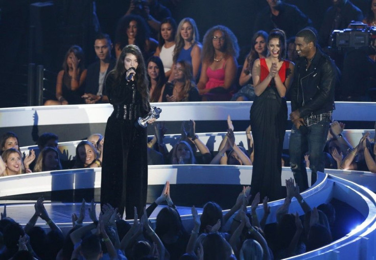 Lorde accepts the award for best rock video for &quot;Royals&quot; as presenters Nina Dobrev and Trey Songz listen during the 2014 MTV Video Music Awards in Inglewood, California August 24, 2014.
