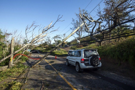 A car navigates past fallen trees and electric cables after Hurricane Gonzalo passed through in Sandys Parish, western Bermuda, October 18, 2014. Hurricane Gonzalo scored a direct hit on Bermuda Friday night into Saturday morning, pummelling the tiny isla