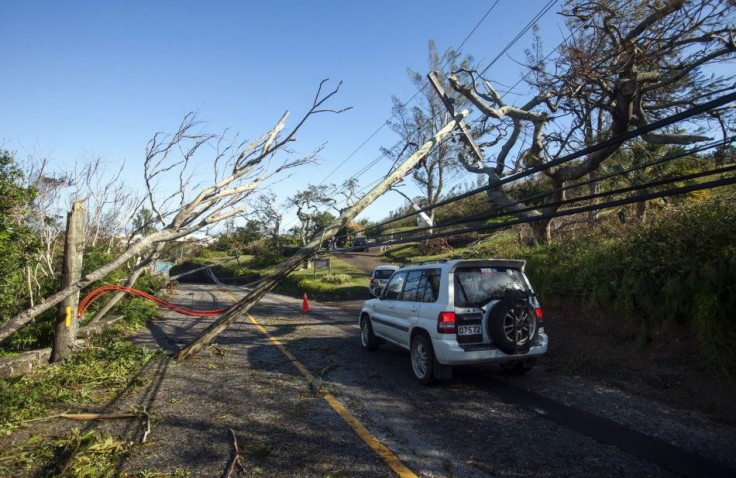 A car navigates past fallen trees and electric cables after Hurricane Gonzalo passed through in Sandys Parish, western Bermuda, October 18, 2014. Hurricane Gonzalo scored a direct hit on Bermuda Friday night into Saturday morning, pummelling the tiny isla