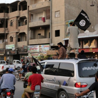 Members loyal to the Islamic State in Iraq and the Levant (ISIL) wave ISIL flags as they drive around Raqqa June 29, 2014. 