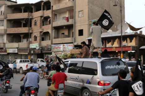 Members loyal to the Islamic State in Iraq and the Levant (ISIL) wave ISIL flags as they drive around Raqqa June 29, 2014. 