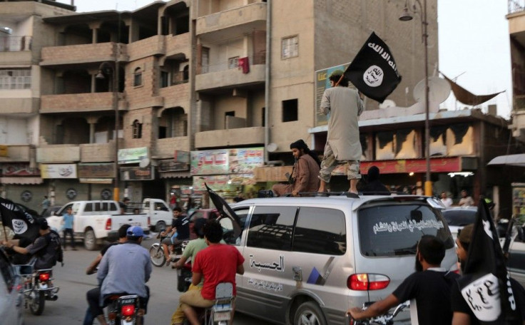 Members loyal to the Islamic State in Iraq and the Levant (ISIL) wave ISIL flags as they drive around Raqqa June 29, 2014. 