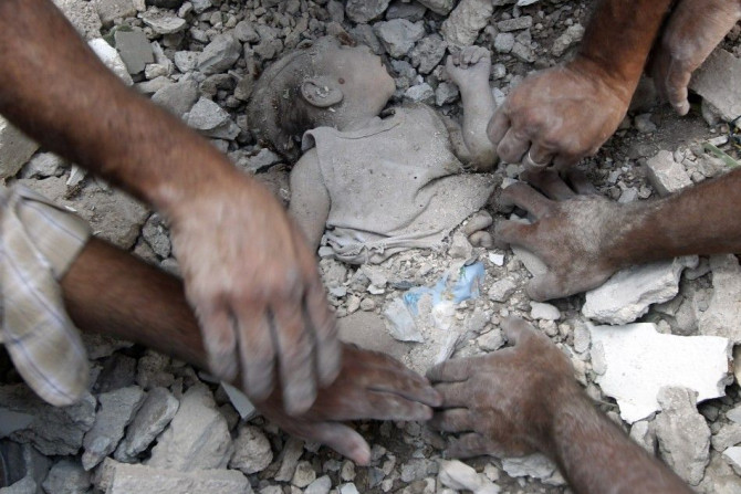 A man clears rubble surrounding a young girl