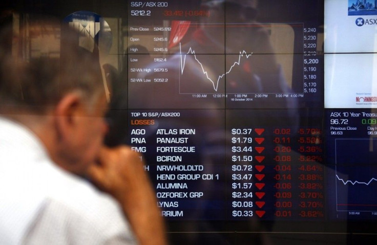 A pedestrian talking on his phone is reflected in the window of the Australian Securities Exchange as an investor watches boards displaying stock prices in central Sydney October 16, 2014. Australian shares slid 1.1 percent on Thursday after U.S. stocks l