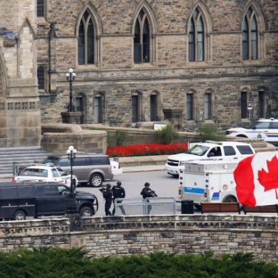 Armed RCMP officers approach Centre Block on Parliament Hilll following a shooting incident in Ottawa October 22, 2014.