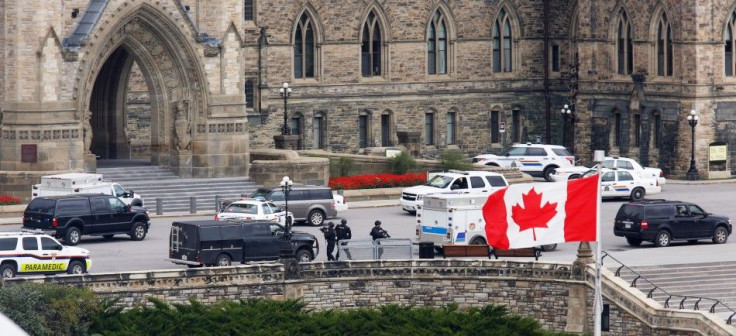 Armed RCMP officers approach Centre Block on Parliament Hilll following a shooting incident in Ottawa October 22, 2014.