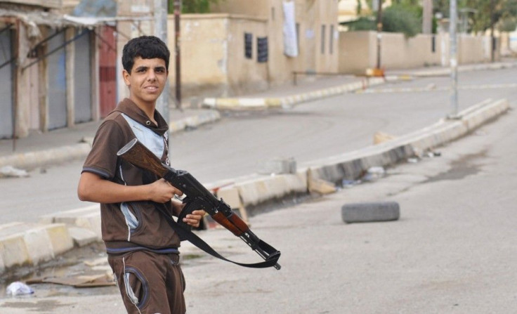 A  Kurdish fighter hold his rifle as he guards the street in the Iraqi town of Qara Tappa north of Baghdad, October 21, 2014. Islamic State militants advanced on the Iraqi town of Qara Tappa, 122 km (73 miles) north of Baghdad, security sources and a loca