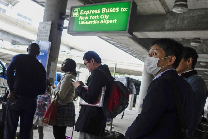 A passenger wears a mask as he exits the International JFK airport in New York October 11, 2014. Medical teams at New York&#039;s JFK airport, armed with Ebola questionnaires and temperature guns, began screening travelers from three West African countrie