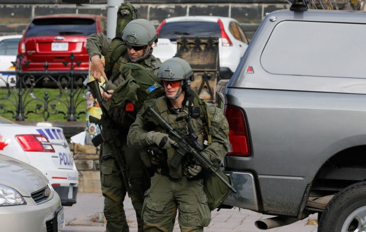 Armed RCMP officers approach Parliament Hilll following a shooting incident in Ottawa October 22, 2014.