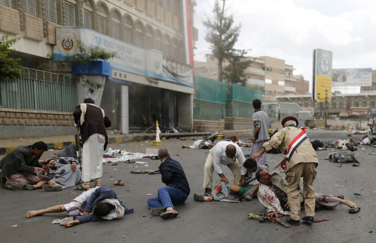 First responders check the wounded and the dead at the site of a suicide attack in Sanaa October 9, 2014. A suicide bomber killed at least 42 people on Thursday when he detonated an explosives-laden belt in a district of the Yemeni capital where the power