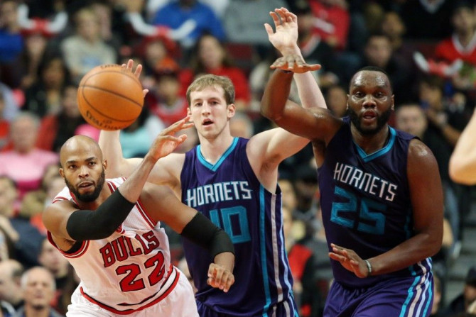 Oct 19, 2014; Chicago, IL, USA; Chicago Bulls forward Taj Gibson (22) passes the ball away from Charlotte Hornets center Cody Zeller (40) and center Al Jefferson (25) during the first half at United Center.