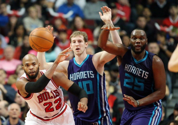 Oct 19, 2014; Chicago, IL, USA; Chicago Bulls forward Taj Gibson (22) passes the ball away from Charlotte Hornets center Cody Zeller (40) and center Al Jefferson (25) during the first half at United Center.
