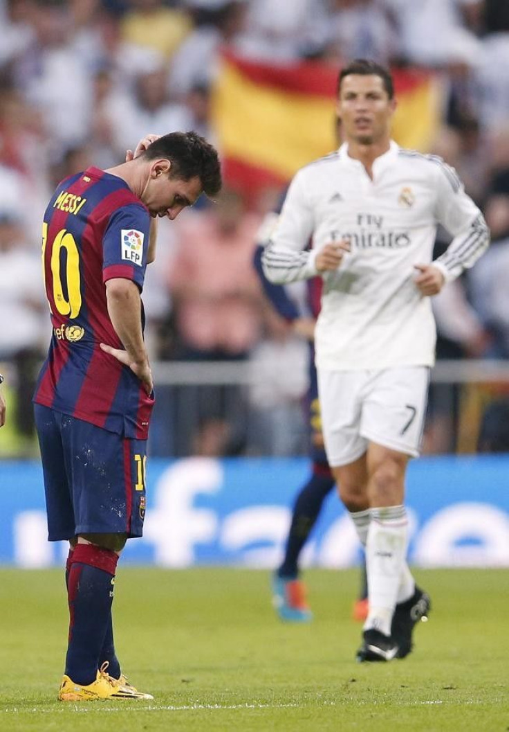 Barcelona's Lionel Messi (L) reacts as Real Madrid's Cristiano Ronaldo closes in