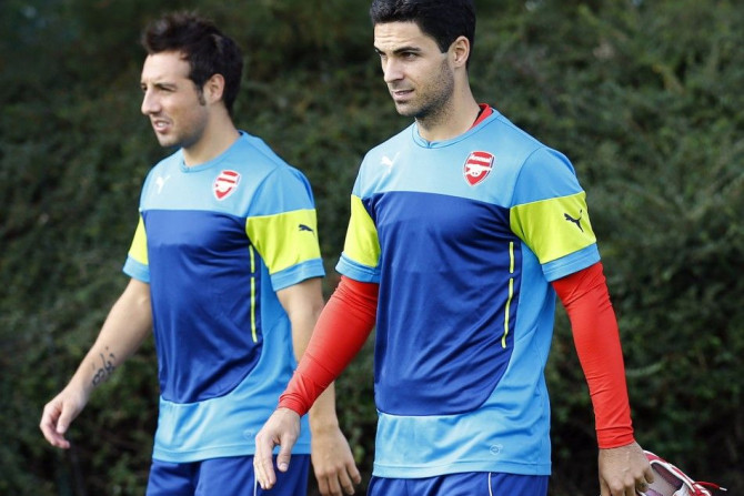 Arsenal&#039;s Mikel Arteta (R) and Santi Cazorla arrive for a training session at their training facility in London Colney, north of London, September 15, 2014. Arsenal are due to play Borussia Dortmund in a Champions League Group D soccer match on Tuesd
