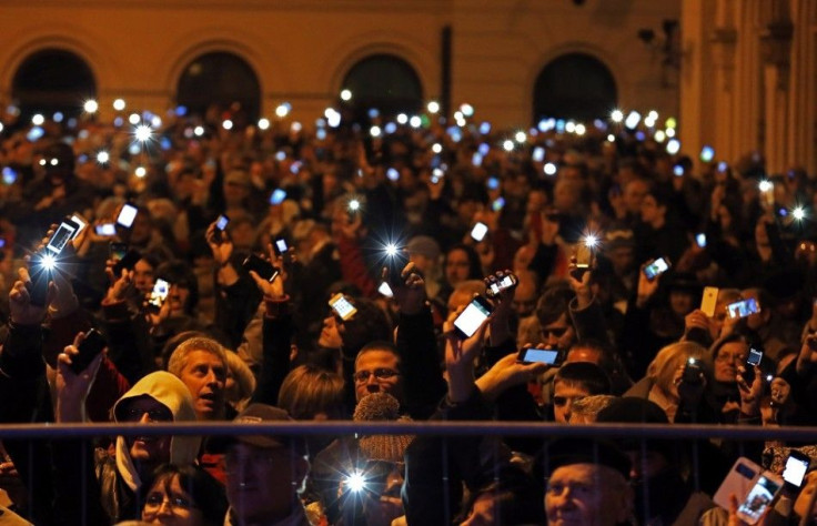 People holds up their mobile phones as they protest against new tax on Internet data transfers in centre of Budapest October 26, 2014. REUTERS/Laszlo Balogh