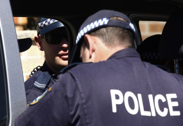 Police stand outside a house that was involved in pre-dawn raids in the western Sydney suburb