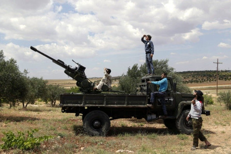 Free Syrian Army fighters look at the sky as they stand on a truck mounted with an anti-aircraft gun in Maarat Al-Nouman, Idlib province May 20, 2014. REUTERS/Khalil Ashawi