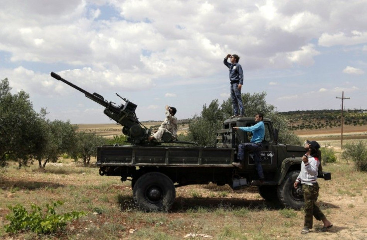 Free Syrian Army fighters look at the sky as they stand on a truck mounted with an anti-aircraft gun in Maarat Al-Nouman, Idlib province May 20, 2014. REUTERS/Khalil Ashawi