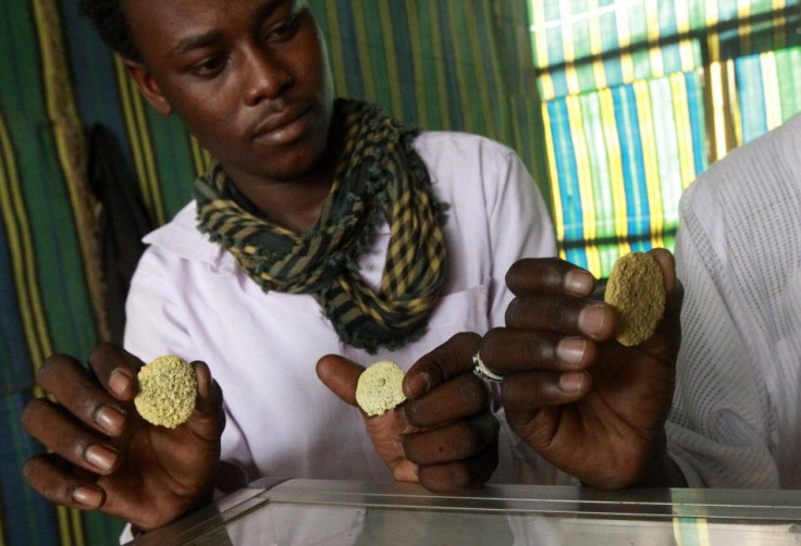 Gold mine workers hold gold nuggets as they weigh them in a local mine in Al-Ibedia locality at River Nile State, July 30, 2013. REUTERS/Mohamed Nureldin Abdallah