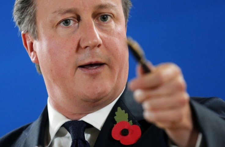 Britain's Prime Minister David Cameron points at reporters as he attends a news conference after an EU summit in Brussels October 24, 2014. Cameron said on Friday Britain would not make an additional 2.1-billion-euro payment into this year's Eur