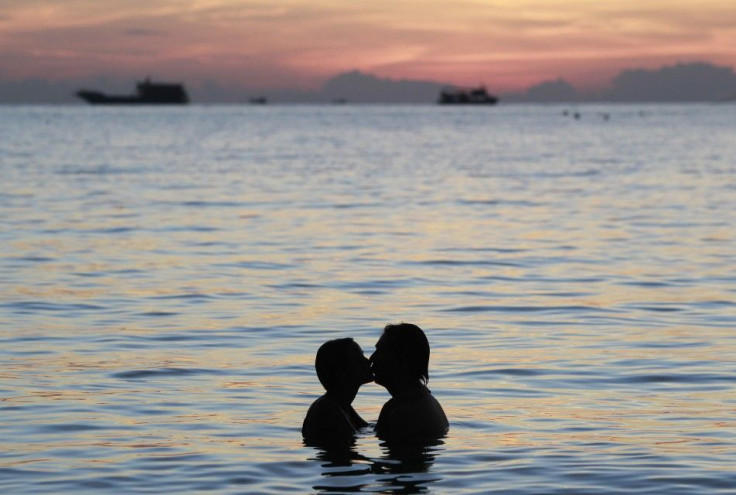 A couple kisses during sunset