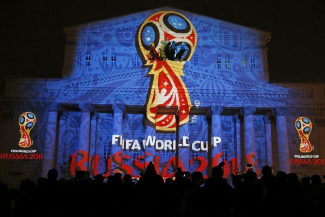 Journalists look at a light installation showing the official logotype of the 2018 FIFA World Cup during its unveiling ceremony at the Bolshoi Theater building in Moscow, October 28, 2014. REUTERS/Maxim Shemetov