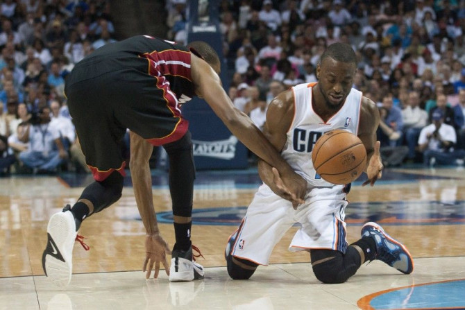 Apr 28, 2014; Charlotte, NC, USA; Charlotte Bobcats guard Kemba Walker (15) tries to grab a ball while falling during the second half against the Miami Heat in game four of the first round of the 2014 NBA Playoffs at Time Warner Cable Arena. The Heat defe