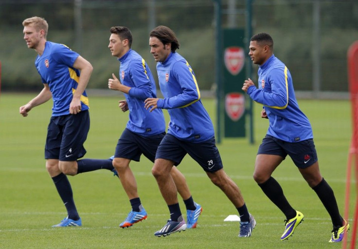 Arsenal's Per Mertesacker (L), Mesut Ozil (2nd L) and Serge Gnabry (R) attend a team training session with ex-Arsenal player Robert Pires at their training ground in London Colney September 30, 2013. Arsenal manager Arsene Wenger has told his players