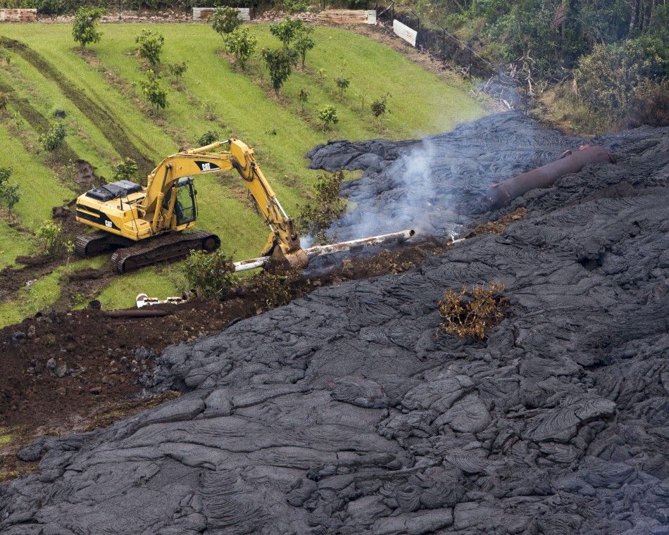 A construction crew tries to contain the lava flow from Mount Kilauea in Pahoa, Hawaii October 29, 2014. The slow-moving river of molten lava from the erupting Kilauea volcano crept over residential and farm property on Hawaiis Big Island on Wednesday af