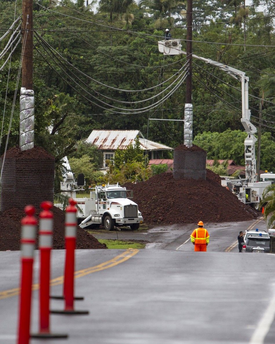 Construction crews attempt to protect power lines as a lava flow from erupting volcano Kilauea approaches the village of Pahoa, Hawaii October 29, 2014. The slow-moving river of molten lava crept across a residential property on Hawaiis Big Island early 