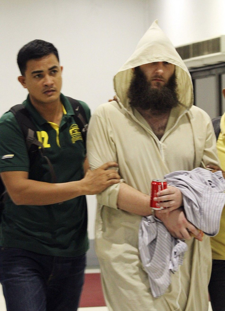 Robert Cerantonio (R), an Australian national and a Muslim convert, is escorted by police intelligence upon arrival at the domestic airport in Manila July 11, 2014.