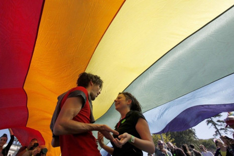 Gay rights activists dance under a rainbow flag during a Pride march in Belgrade, September 28, 2014. Gay rights activists in Serbia held their first Pride march in four years on Sunday, walking through Belgrade streets emptied of traffic and pedestrians 