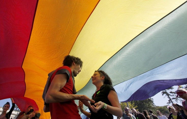 Gay rights activists dance under a rainbow flag during a Pride march in Belgrade, September 28, 2014. Gay rights activists in Serbia held their first Pride march in four years on Sunday, walking through Belgrade streets emptied of traffic and pedestrians 