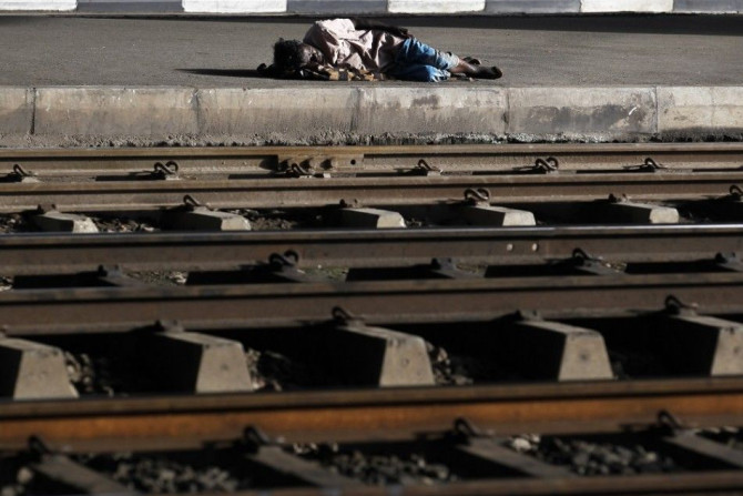 A man sleeps next to railway tracks on a side of a road in Colombo October 24, 2014. Sri Lankan President Mahinda Rajapaksa, who is expected to soon seek a third six-year term, announced a 2015 budget on Friday that trims the value-added tax and reduces t