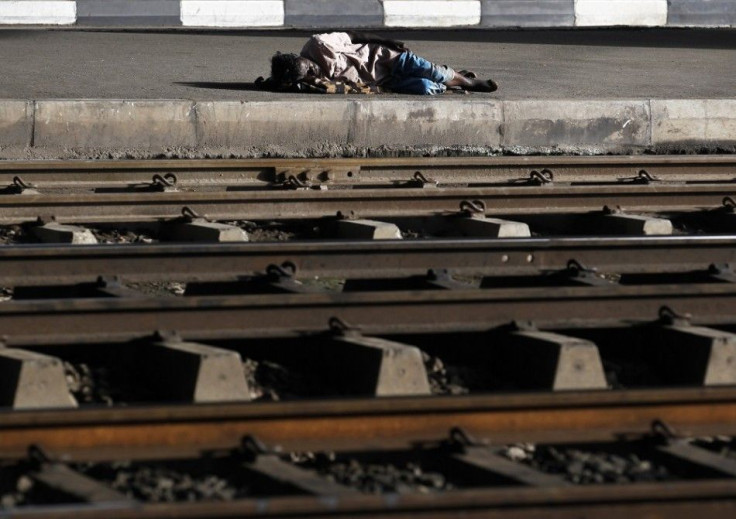 A man sleeps next to railway tracks on a side of a road in Colombo October 24, 2014. Sri Lankan President Mahinda Rajapaksa, who is expected to soon seek a third six-year term, announced a 2015 budget on Friday that trims the value-added tax and reduces t