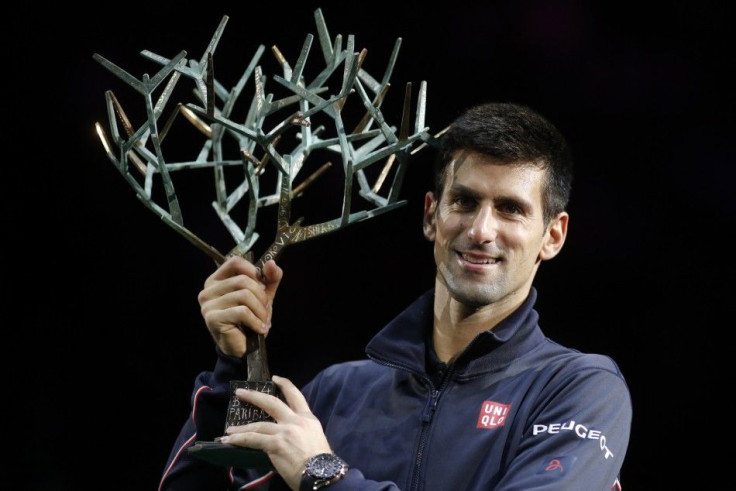 Novak Djokovic of Serbia holds his trophy as he poses for pictures after winning the men&#039;s singles final match against Milos Raonic of Canada at the Paris Masters tennis tournament at the Bercy sports hall in Paris, November 2, 2014. REUTERS/Benoit T