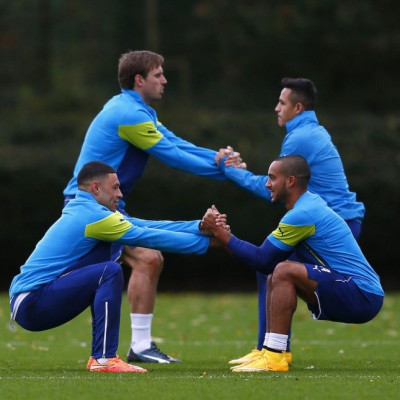 Arsenal players (L-R) Alex Oxlade-Chamberlain, Nacho Monreal,Theo Walcott and Alexis Sanchez warm up during a training session at their training facility in London Colney, north of London, November 3, 2014. Arsenal are due to play Anderlecht in a Champion